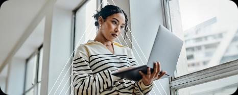 woman holding a laptop looking intently at it